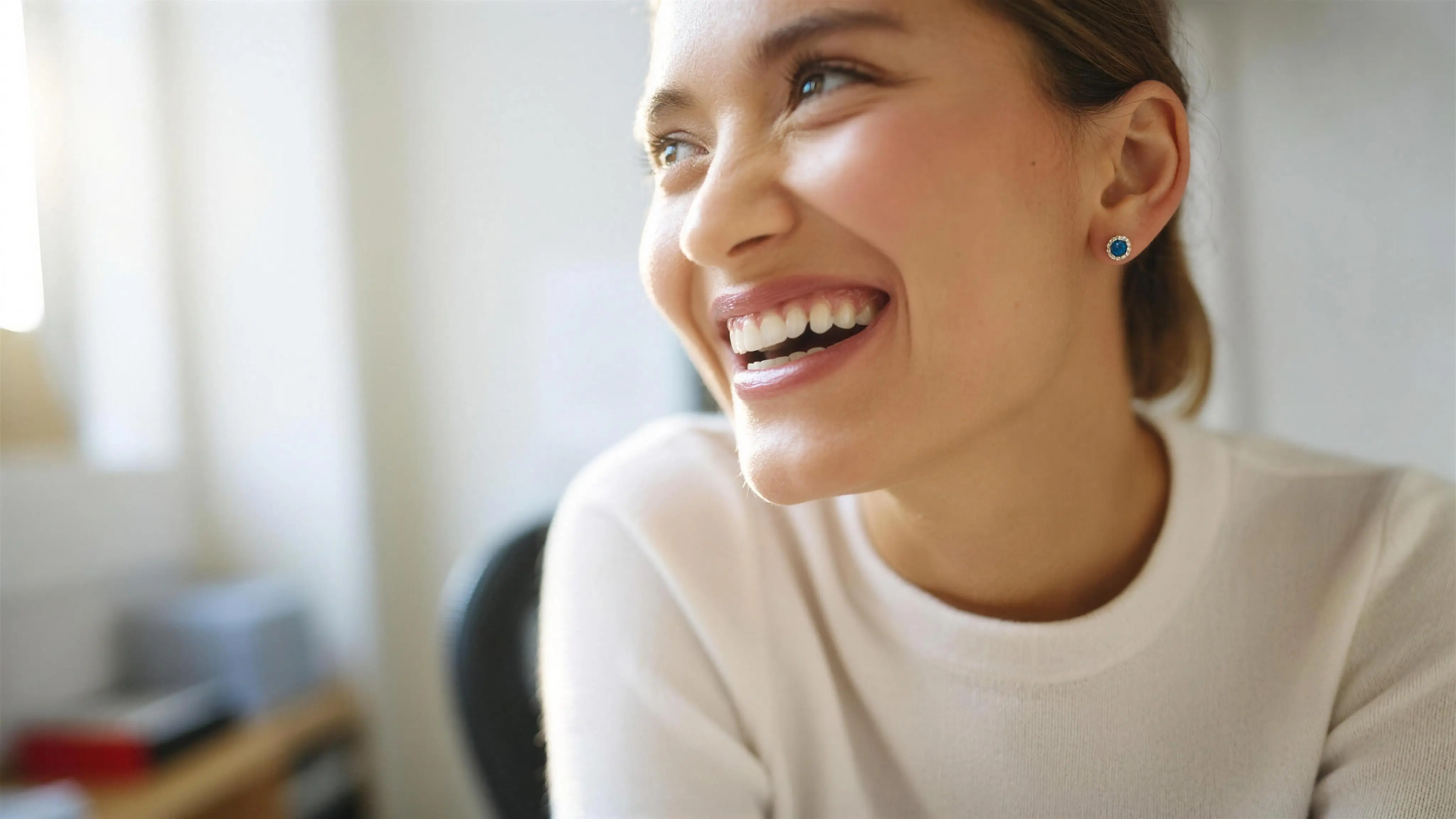 A smiling young woman in morning light