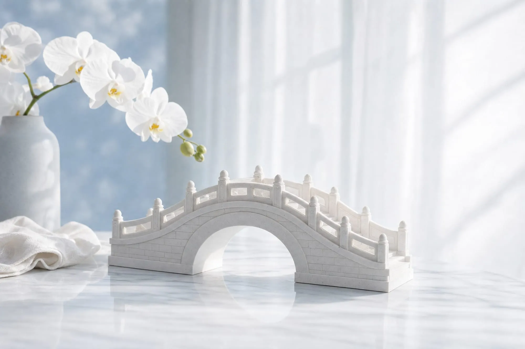 An elegant white stone arch maquette standing on a porcelain surface