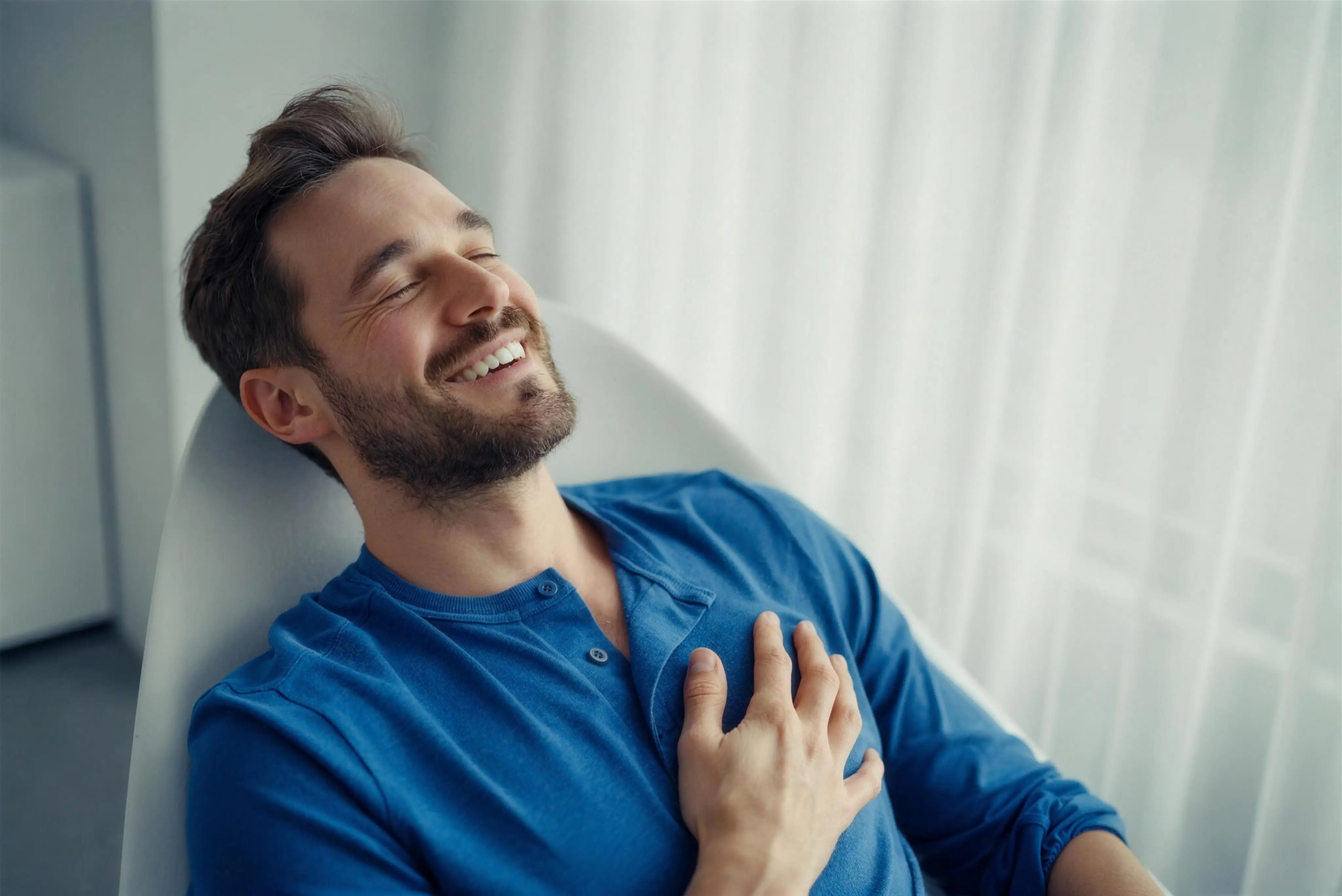 A relieved patient reclining with a hand resting on his chest